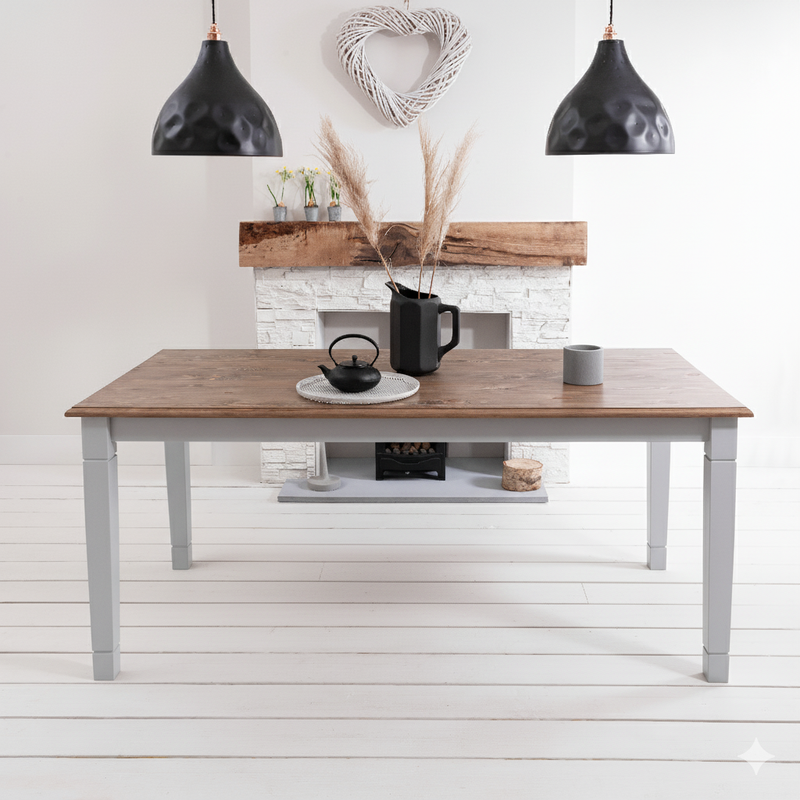 Dining table with a wooden top and gray base in a room with a fireplace and decorative items.
