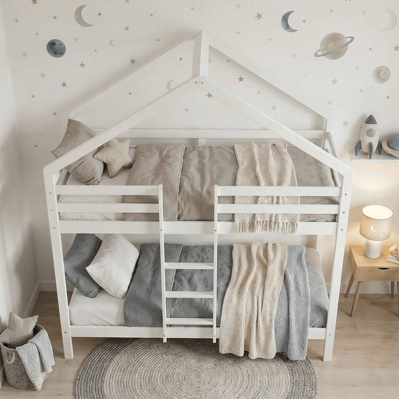 Children's bedroom with a white house-shaped bed, moon and star wall decals, and wooden nightstands.