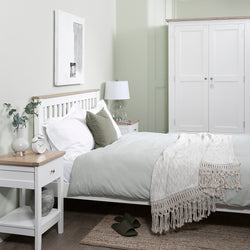 Neatly arranged bedroom with a bed, nightstands, and a wardrobe.